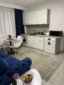 a living room with a blue couch and a kitchen at Escape Aparthotel in Suceava