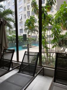 2 sedie in una camera con vista sulla piscina di Aconchegante & charmoso a Rio de Janeiro