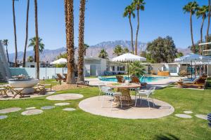 a yard with a table and chairs and a pool at Monkey Tree Hotel by AvantStay Stylish Hotel in Palm Springs w Pool in Palm Springs