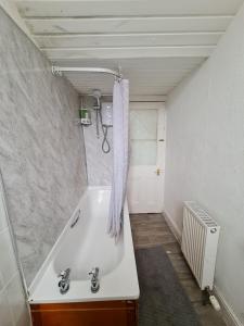 a bathroom with a bath tub and a shower at Haymarket Station Rooms in Edinburgh