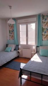 ein Schlafzimmer mit zwei Betten und einem Fenster in der Unterkunft Maison Cosne sur Loire in Cosne-Cours-sur-Loire