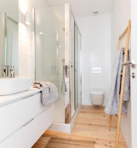 y baño blanco con lavabo y ducha. en Loft in the city, en Madrid