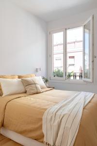 una camera bianca con un grande letto e una finestra di Loft in the city a Madrid