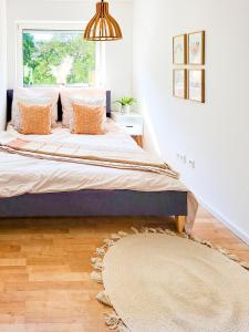 a bedroom with a bed with a window and a rug at Stilvolle 3-Zimmer Wohnung in Ingolstadt mit Balkon und guter Autobahnanbindung in Ingolstadt