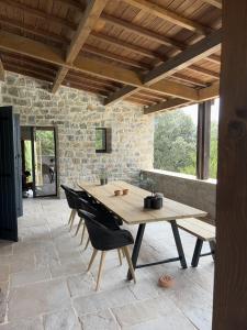 einen Holztisch und Stühle auf einer Terrasse in der Unterkunft Luxurious family house with pool in Ardèche. in Les Vans