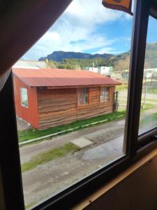 a view of a house from a window at Alma Patagona Hostel in Puerto Tranquilo