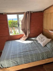 a large bed in a room with a window at Solar Valizas in Barra de Valizas