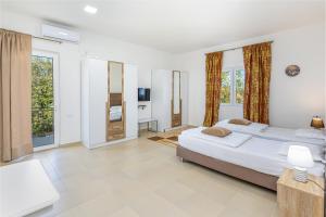 a bedroom with two beds and a television in it at Apartments Lustica in Tivat
