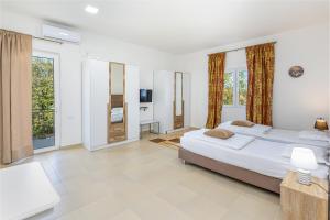 una camera da letto con due letti e una televisione di Apartments Lustica a Tivat Altre 17 foto