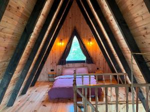 1 dormitorio en una cabaña de madera con 1 cama. en Çekirge Bungalov, en Sakarya