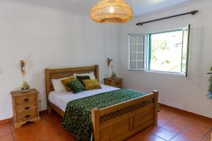 a bedroom with a bed and a window at O Refúgio in Praia
