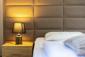 1 dormitorio con cama y mesita de noche con lámpara en Apartments Lustica en Tivat