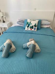 uma cama azul com sapatos e toalhas em Modern Apartment in Pafos Near the Sea em Pafos