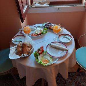 una mesa con platos de comida y vasos de zumo de naranja en Casa de David, en Monsanto