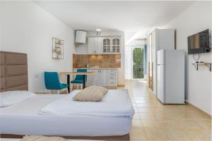 a bedroom with a bed and a kitchen with a refrigerator at Apartments Lustica in Tivat