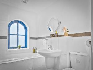 Baño blanco con lavabo, aseo y espejo en Preston Serviced Apartment - Estatevision, en Preston