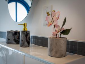 two vases with flowers on a counter in a bathroom at Preston Serviced Apartment - Estatevision in Preston