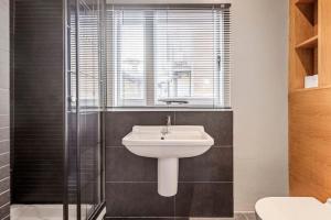 a bathroom with a sink and a glass shower at Spacious Home on Chapel Market in London +20 photos