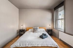 a white bedroom with a bed with two night stands at Spacious Home on Chapel Market in London