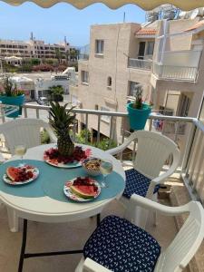 uma mesa e cadeiras com pratos de comida numa varanda em Modern Apartment in Pafos Near the Sea em Pafos