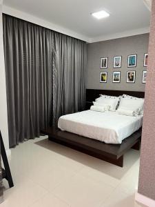 Un dormitorio con una cama grande y una ventana en Apartamento JURERE en Florianópolis