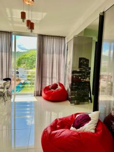 a living room with a red couch in front of a window at Apartamento JURERE in Florianópolis