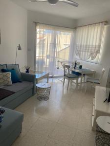 uma sala de estar com um sofá e uma mesa em Modern Apartment in Pafos Near the Sea em Pafos