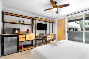 1 dormitorio con 1 cama y escritorio con TV en Hacienda Santa Barbara by Homi Rent en El Jacal