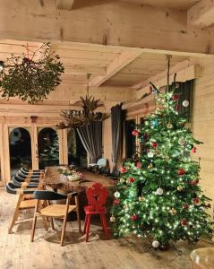 a christmas tree in a room with a table at Bajkowa Chata 3 Magiczne Domki Jacuzzi in Murzasichle