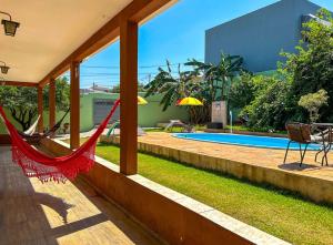 a hammock in the backyard of a house with a pool at Otima casa de campo com churrasq em Sorocaba SP in Sorocaba