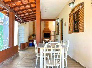 ein Esszimmer mit einem Tisch und weißen Stühlen in der Unterkunft Otima casa de campo com churrasq em Sorocaba SP in Sorocaba