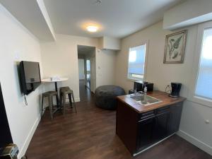 a bathroom with a sink and a living room at Brand New 1 Br 1 Bath Close To All Walkable in Edmonton