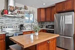 a kitchen with wooden cabinets and a stainless steel refrigerator at Work and Gym Hideaway in San Jose