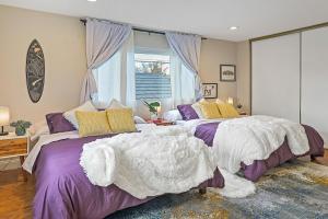 two beds in a bedroom with purple and yellow pillows at Work and Gym Hideaway in San Jose