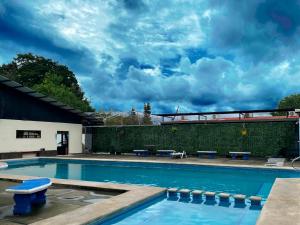 una piscina con un banco frente a un edificio en Hotel Grecia Costa Rica en Grecia