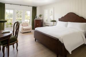 a bedroom with a large bed and a desk and a chair at The Inn at Rancho Santa Fe in Rancho Santa Fe