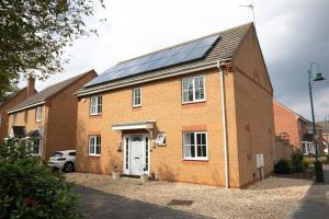 una casa de ladrillo con paneles solares en el techo en Detached house with BIG monthly discount!, en Peterborough