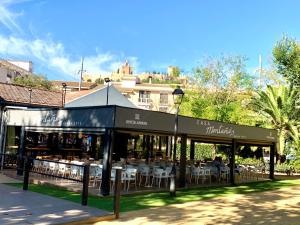 un restaurante con mesas blancas y sillas en la hierba en Alcalá zona Centro en Alcalá la Real