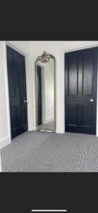 un espejo en una habitación con dos puertas negras en Bloww lodge en Oulton