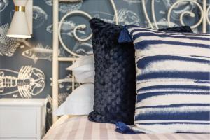 a bed with blue and white pillows on it at Captain's Quarters in Hythe