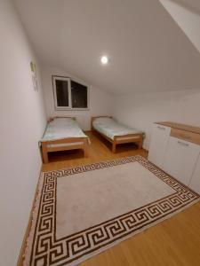 a living room with two beds and a rug at Apartman Riki in Sarajevo