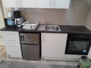 a kitchen with a sink and a microwave at ND'S APARTMENT in Phibblestown