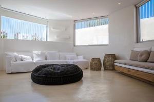 a living room with two white couches and a large ottoman at Seafront Athens Riviera Lagonisi Villa in Lagonissi +14 photos