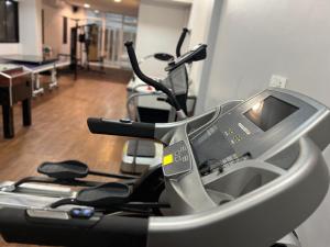 a gym with a treadmill and two exercise bikes at Hotel Golf Coast in Kinshasa
