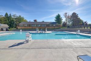 - une piscine avec 2 chaises et une maison dans l'établissement Tobyhanna Abode with Golf and Pool Access!, à Tobyhanna