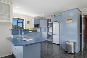 eine Küche mit blauen Schränken und einer blauen Arbeitsplatte in der Unterkunft Mountain Majesty on Orchard-Wanaka Holiday Home in Wanaka