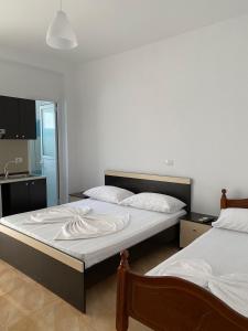 a bedroom with two beds with white sheets at VILLA MARLEN in Ksamil