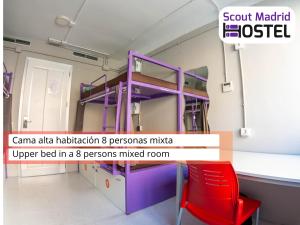 Zimmer mit einem Etagenbett und einem roten Stuhl in der Unterkunft Scout Madrid Hostel in Madrid