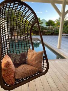 Saint Martin的住宿－Orient Bay villa，门廊上的带枕头的藤椅