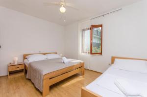 a bedroom with two beds and a window at Apartments Seafront Jadranka in Stara Novalja
